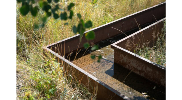 Water traces a hand-chiseled basalt surface, where subtle texture adds depth and tactility. Set against corten steel, this restrained composition reflects the design’s broader ethos—letting craft and materiality speak louder than ornament.